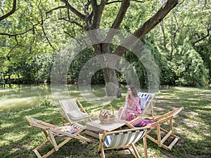 People on canvas chair in garden having afternoon tea and relaxing.