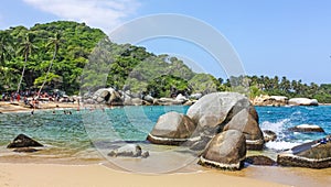 People in Caribbean beach with tropical forest in Tayrona National Park, Colombia. Tayrona National Park is located in the photo