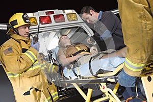 People Carrying Patient On Stretcher In Ambulance