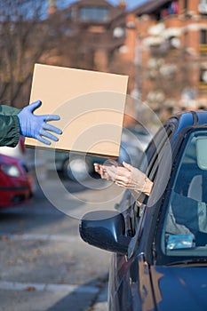 people in cars at distribution point giveaway receiving handouts