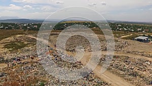 People and cars are working in the city dump. bird`s-eye view.