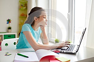 Bored girl with laptop and notebook at home