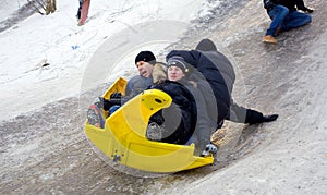 People Children ride on the winter snow sledding from hills. Winter playing, fun, snow