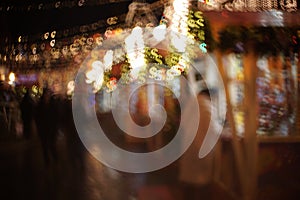 People in the Christmas market buy gifts. Abstract dollar bokeh lights background