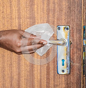 People cleaning door knobs and handle using alocohol based tissue and disinfectant to fight covid-19 or corona virus pandemic