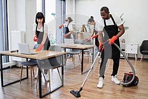 People of cleaning service cleans tables, floor, and panoramic windows.