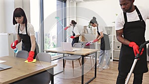 People of cleaning service cleans tables, floor, and panoramic windows.