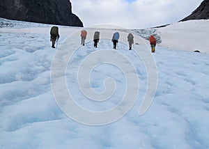 People climbers, climbing snow summit, rocky mountain peaks and glacier in Norway