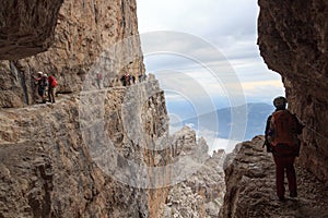 People climbing on via ferrata Sentiero delle Bocchette Centrale in Brenta Dolomites mountains, Italy