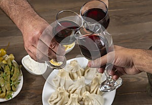 People clinking glasses with wine in front of bokeh background