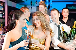 People in club or bar drinking champagne