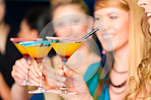 People in club or bar drinking cocktails