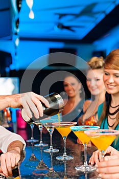 People in club or bar drinking cocktails