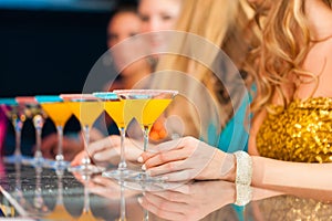 People in club or bar drinking cocktails