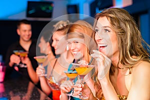 People in club or bar drinking cocktails