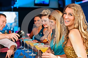 People in club or bar drinking cocktails