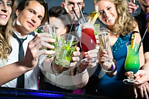 People in club or bar drinking cocktails