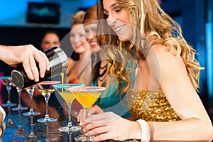 People in club or bar drinking cocktails