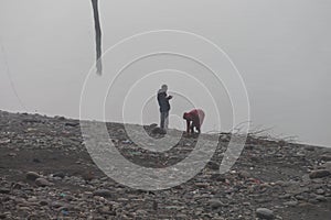 People collecting dry wood for fire at Basohli, on a cold foggy winter day