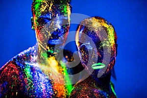 People are colored fluorescent powder. a pair of lovers dancing at a disco