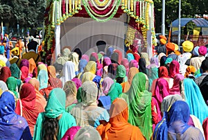people with colorful clothes and women with veil during the reli
