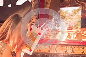 People come to pray with joss sticks burning at a vintage Buddhist temple as offering during Chinese New Year in temple