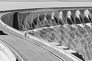 People compared to Gariep Dam overflowing. Monochrome