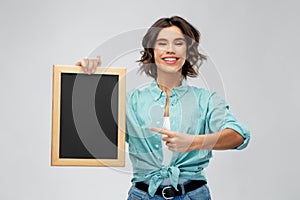 Portrait of smiling woman showing black chalkboard