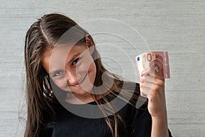 people concept - smiling teenage girl in pullover holding ten euros money banknotes over grey background