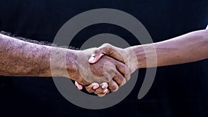 People concepts. Two men shaking hands isolated on black background