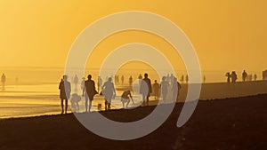 People in contre-jour light at the beach. Maspolomas beach on Canary island