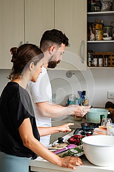 People cooking at home. Young couple preparing something healthy to eat. photo