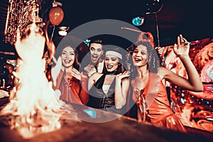 People in Costumes Looking at Flaming Cocktail