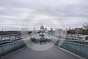 People cross the Millennium Bridge, London