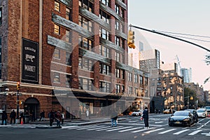 People cross 9th Avenue in front of Chelsea Market in Manhattan, USA