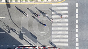 People crowd walk in top view at street city with pedestrian crosswalk in traffic road with light and shadow silhouette