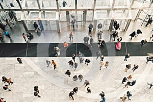 People crowd walking in the business centre and shopping mall entrance. View from the top.