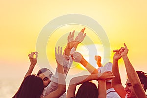 People dancing at the beach with hands up. concept about party, music and people photo