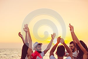 People dancing at the beach with hands up. concept about party, music and people photo