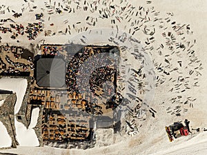 People dancing in a mountain bar in the ski resort of Les 2 Alpes, France. Aerial drone view of people enjoying apres-ski. Apres