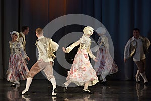 People dancing in traditional costumes on stage,