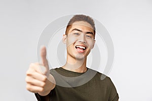 People, different expressions and lifestyle concept. Close-up portrait of upbeat, rejoicing asian man saying yes, show