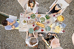 People dining outdoors, view on table from above