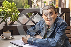 People with disabilities sitting in a cafe and writing in a notebook