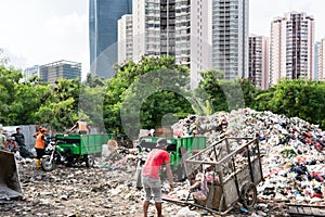 People disposing waste materials and garbage in a landfill site