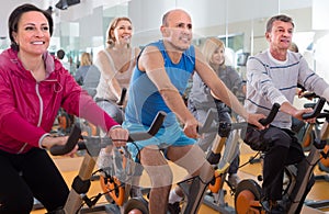 People do sports on exercise bikes