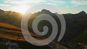 People with dogs walk on hill in giant mountains at sunset