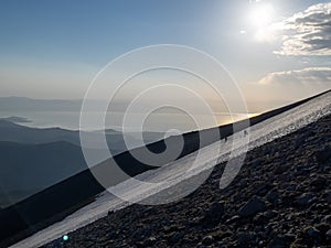 People doing high mountain activity with lake views