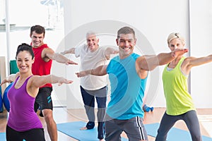 People doing warrior pose in yoga class