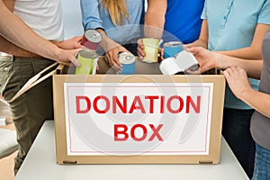 People with donation box holding cans